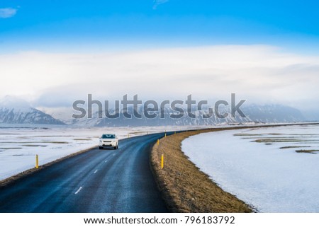 Beautiful View of straight Iceland's golden circle road surrounding by snow with snow-capped mountain as a background and winter season, winter landscape.