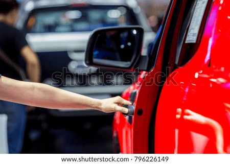 Girl's hand pulling a car's door handle
