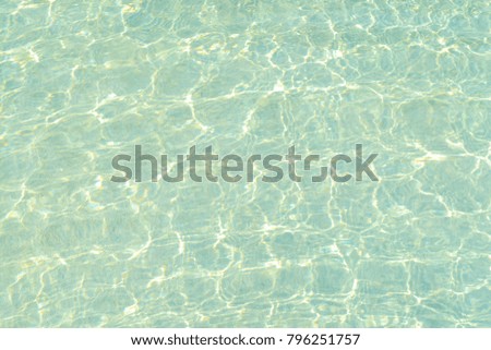 Swimming pool blue water with a wave and sunlight reflection 