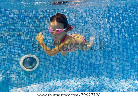 Active underwater kid in swimming pool. Girl swims and having fun. Child sport on summer vacation