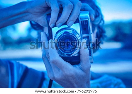 Woman taking pictures with vintage at dusk camera. Travel. Horizontal