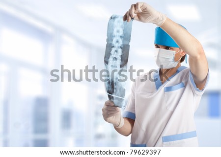 medical doctor looking at x-ray picture of spinal column in hospital with copy space
