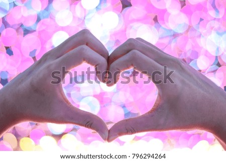 Female hands heart shape with pink bokeh background for valentine day