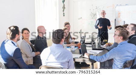 Relaxed informal IT business startup company meeting. Team leader discussing and brainstorming new approaches and ideas with colleagues. Startup business and entrepreneurship concept. Royalty-Free Stock Photo #796315264