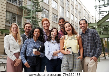 Friendly coworkers laugh to camera outside their workplace Royalty-Free Stock Photo #796332433