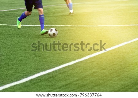 Closeup of a soccer ball and soccer player at the stadium. A beautiful football field with markings.