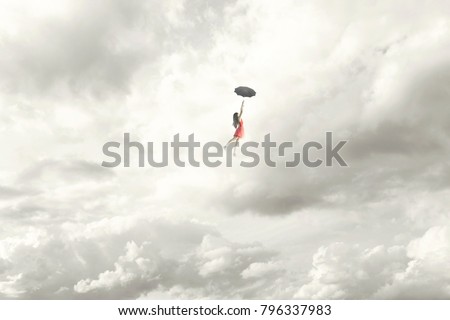 Surreal moment of an elegant woman flying in the middle of the clouds hanging on her umbrella Royalty-Free Stock Photo #796337983