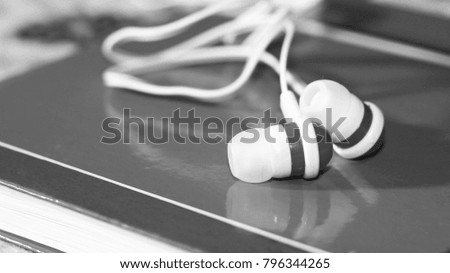 Close up on black and white earbuds, a trendy device for the player, sound