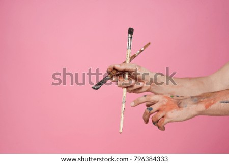 brush for drawing in hand on a pink background                               