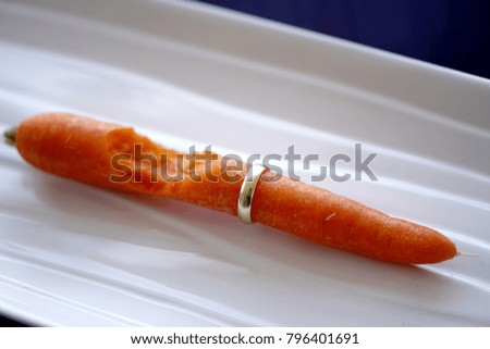 A carrot with a gold ring and bit taken out of it.eat carrot gold