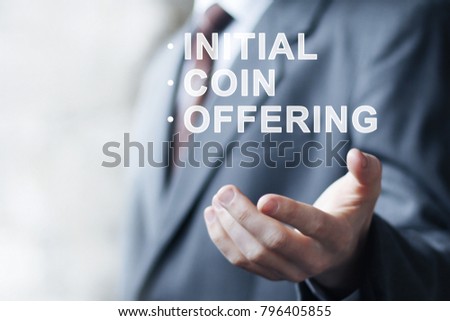 Businessman presses button ICO Initial Coin Offering on virtual digital electronic user interface.