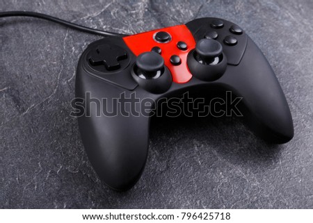 A joystick from the game console . On a dark stone background.