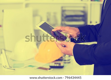 Man using touchscreen phone on background with blured office interior