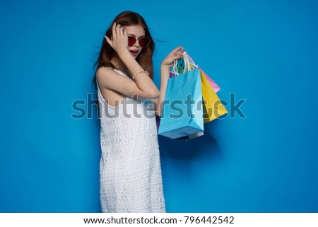   young beautiful woman with shopping on blue background                             