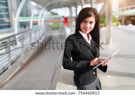 beautiful businesswoman standing and using tablet (this image for business and technology concept)
