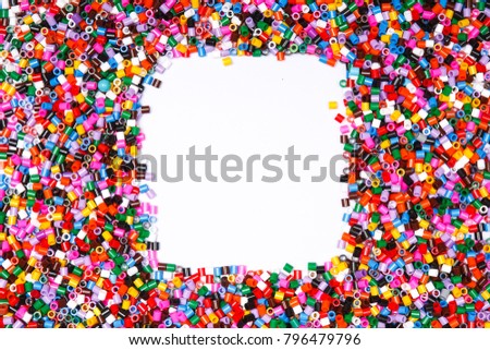 Frame in the shape of square. Background of multicolored decorative plastic craft beads.  