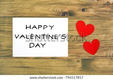 White paper with message for Valentine's day and hearts on wooden table.Image is intentionally toned.