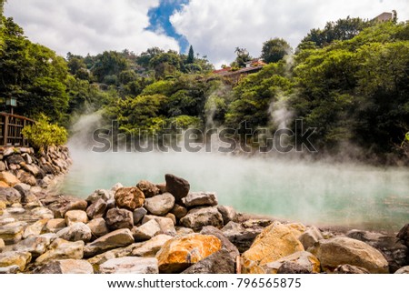 The hot spring at Beitou Thermal Valley, covered with mists, is nearly 100 degrees Celsius hot. The rocks in this photo are rare and called hokutolite. They contain the radioactive element Radium. Royalty-Free Stock Photo #796565875