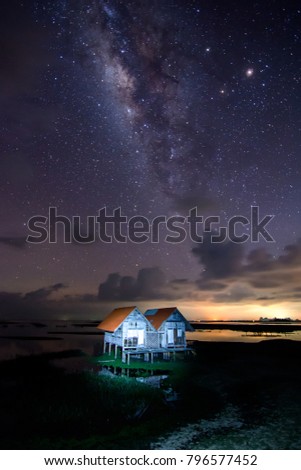 vertical milky way over abandoned farmhouse in clear sky night .