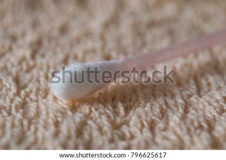 closeup of pink cotton swab on bath towel texture