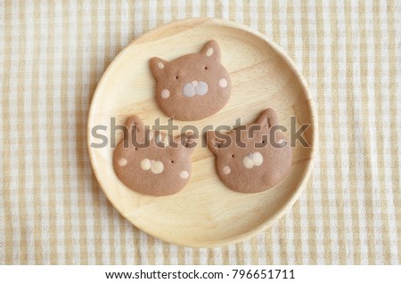 Homemade Chocolate Cookies Cat Face in Wooden Plate on middle frame 