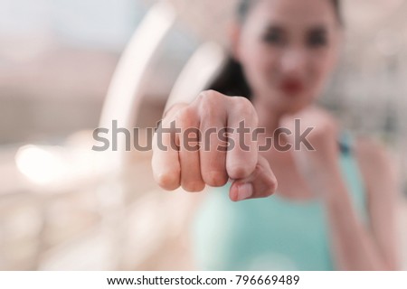 Woman clenched fist ready to punch close up with copy space. workout for martial art boxing, self defense.  Royalty-Free Stock Photo #796669489