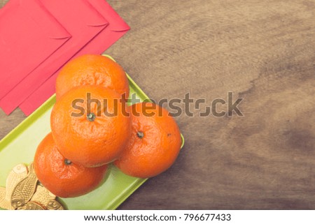 Flat lay image style of Chinese New Year & Lunar Holiday Top view Teapot & Mandarin Orange also Red Pocket Money on Wooden Table Background