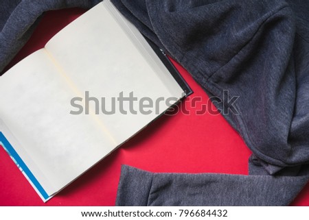The book is placed on a red background with a shirt placed next to it. Make it more interesting.

