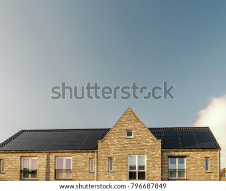 Newly build houses in the Netherlands with solar panels attached on the roof against a sunny sky Close up of new building  black solar panels.Zonnepanelen Translation: Solar  panel, Sun energy