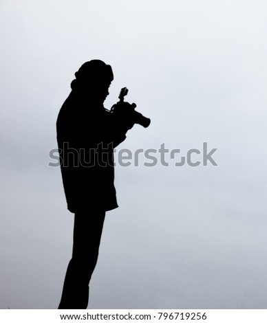 Silhouette of a photographer like to travel and photography, looking pictures in his camera