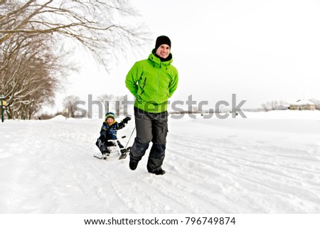Father drag his boy in sled