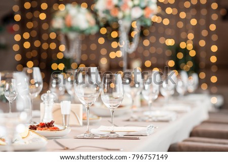 focus on glasses. Banquet table in the restaurant, the preparation before the banquet. the work of professional florists. Royalty-Free Stock Photo #796757149