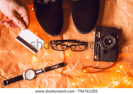 Beautiful background. top view. credit card, glasses, garland, shoes, watch, hand, camera.