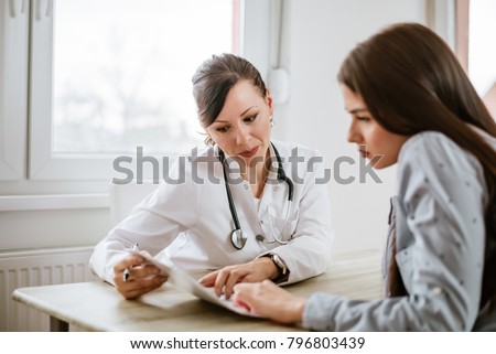 Charming female doctor giving advice to a female patient.  Royalty-Free Stock Photo #796803439