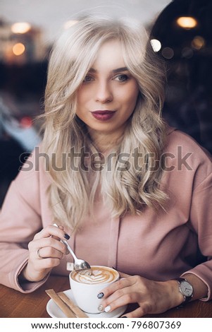 shooting in the coffee shop, the portrait of a young woman through the picture window, with coffee in hand