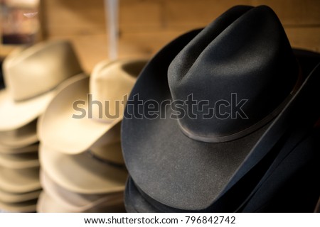 Side perspective close up on a stack of traditional black felt cowboy hats, with wide western brims Royalty-Free Stock Photo #796842742