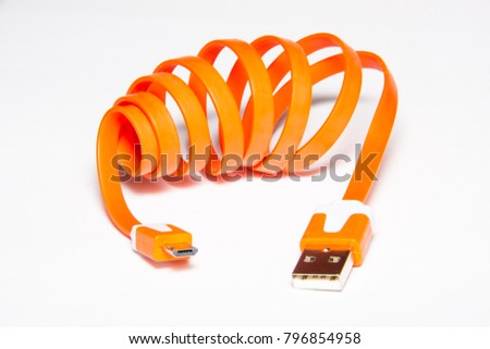 Coiled USB cable. Orange color. Orange micro USB data and power cable for smartphones. Isolated on white background.