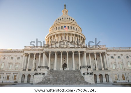A ground view photo of the front of The Capitol Building in Washington, D.C. with bright blue sky.   Royalty-Free Stock Photo #796865245