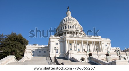 Looking up the rear steps of The Capitol Building in Washington, D.C. with a bright blue sky.   Royalty-Free Stock Photo #796865257