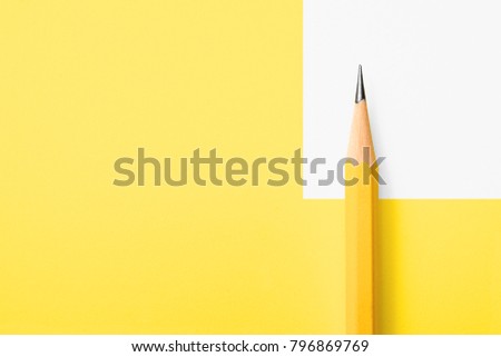 Minimalist template with copy space by top view close up macro photo of wooden yellow pencil isolated on yellow paper and combine with white graphic.Flash light made smooth shadow from yellow pencil.