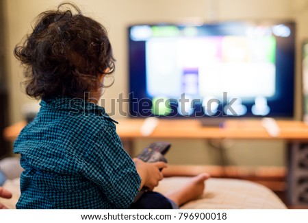 Young Indian boy watching television