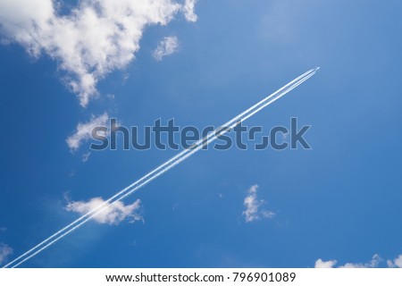 Airplane contrail against skyblue sky with white cloud . Royalty-Free Stock Photo #796901089