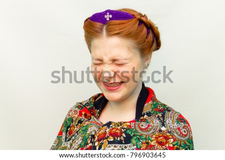 girl with a hair style in a Slavic style laughs.