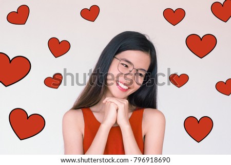 Valentines Day concept- Headshot portrait of long black hair young asian woman wearing red dress making a wish and smiling with red heart illustration doodle icon at the back groun