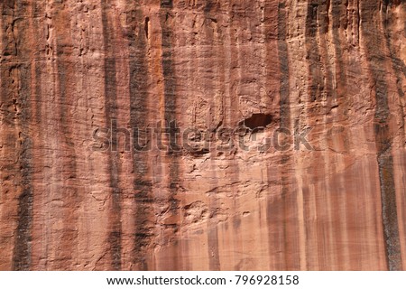 Closeup of a rock wall with colorful water streaks