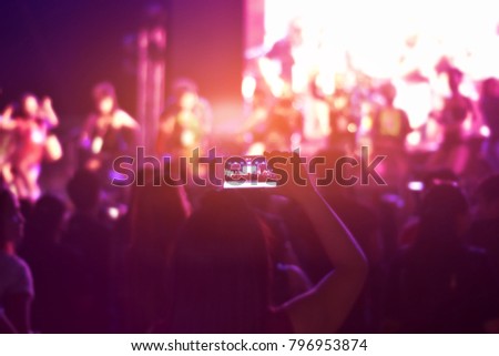 Women using smartphone take a photo in concert,Happy new year party,Ultra violet tone