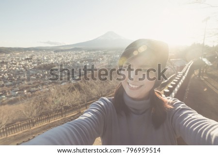 Portrait of Attractive asian woman making selfie photo with moutain Fuji background on sunset