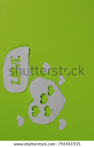 Symbol of love made by white paper on green background
