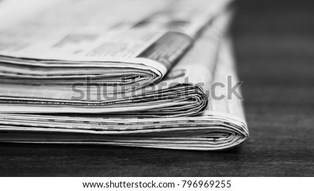 Newspapers. Pile of folded and stacked pages with news on the table. Selective focus on paper, blurred background