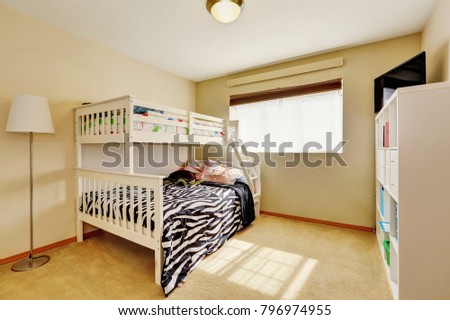 Sunny beige kids' room with a bunk bed with built-in ladder and dressed in zebra print bedding. Northwest, USA